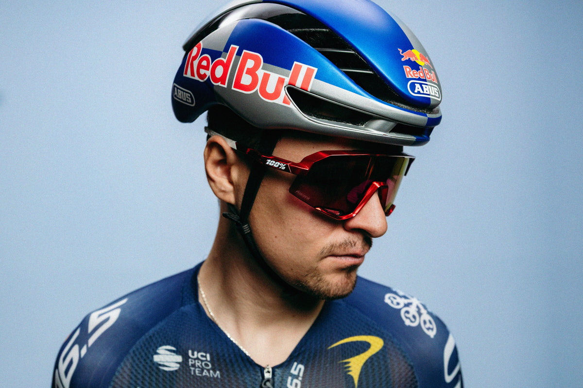 Tom Pidcock wearing his limited-edition 100Percent® Slendale® Sunglasses on a  blue background.