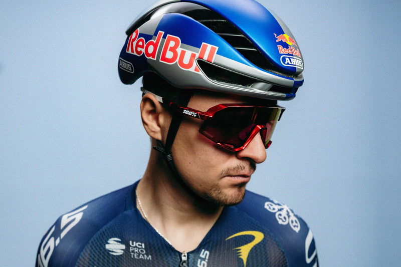 Tom Pidcock wearing his limited-edition 100Percent® Slendale® Sunglasses on a  blue background.